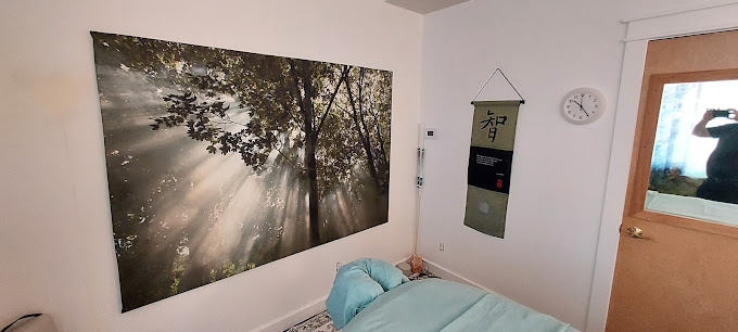 A bedroom with a painting hanging on the wall