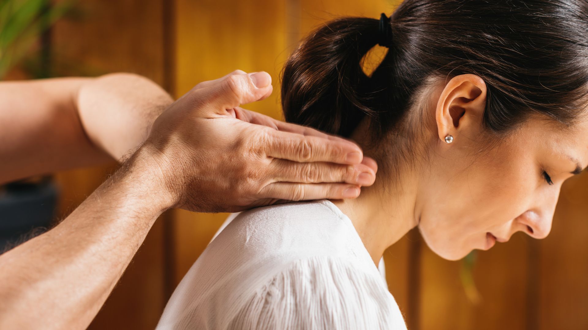 A woman getting a neck massage from a man