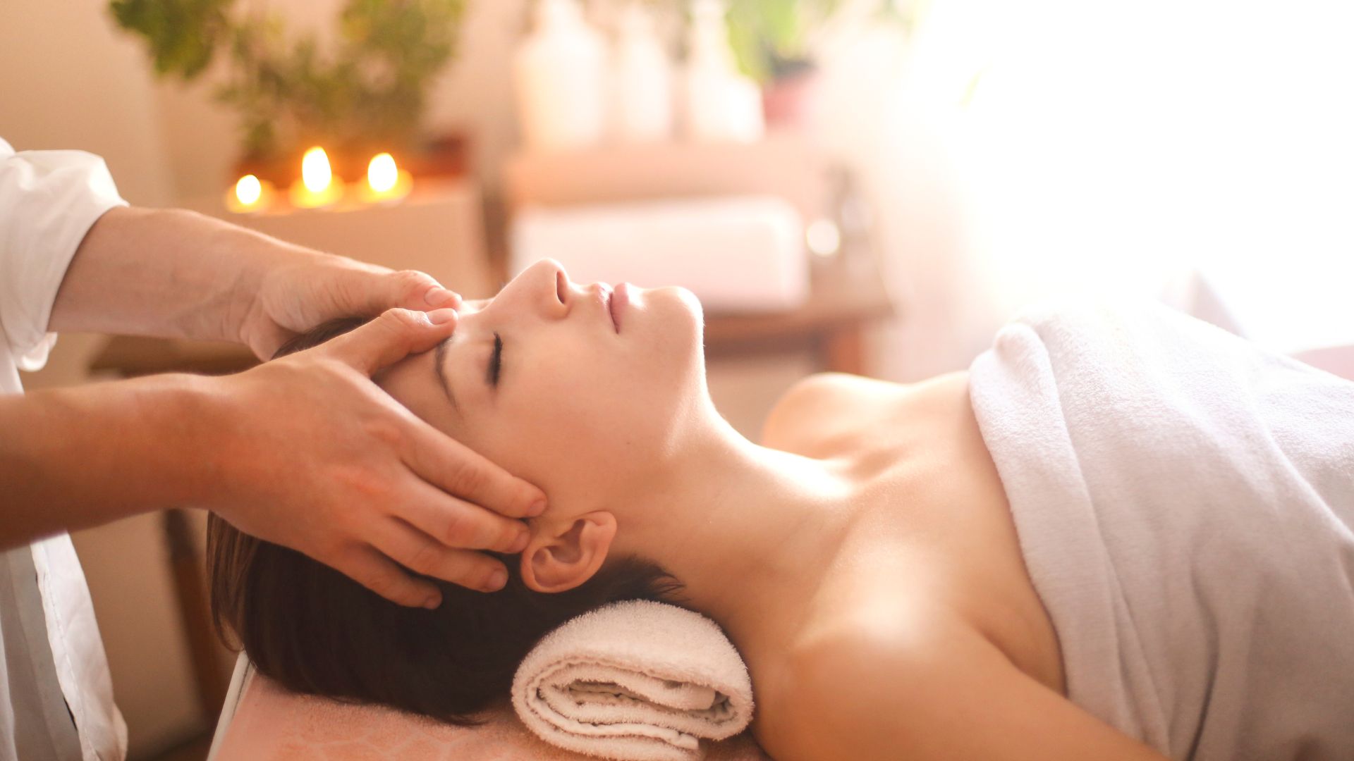 A woman getting a facial massage at a spa